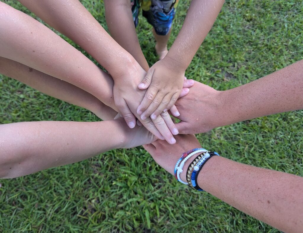 Hands stacked on top of each other in a huddle