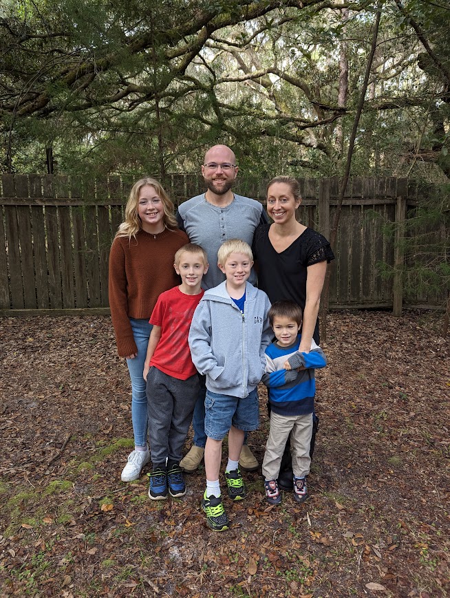 Rusty and Jessica with 4 kids in front of wooden fence