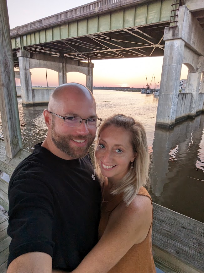 Rusty and Jessica in front of a bridge at sunset