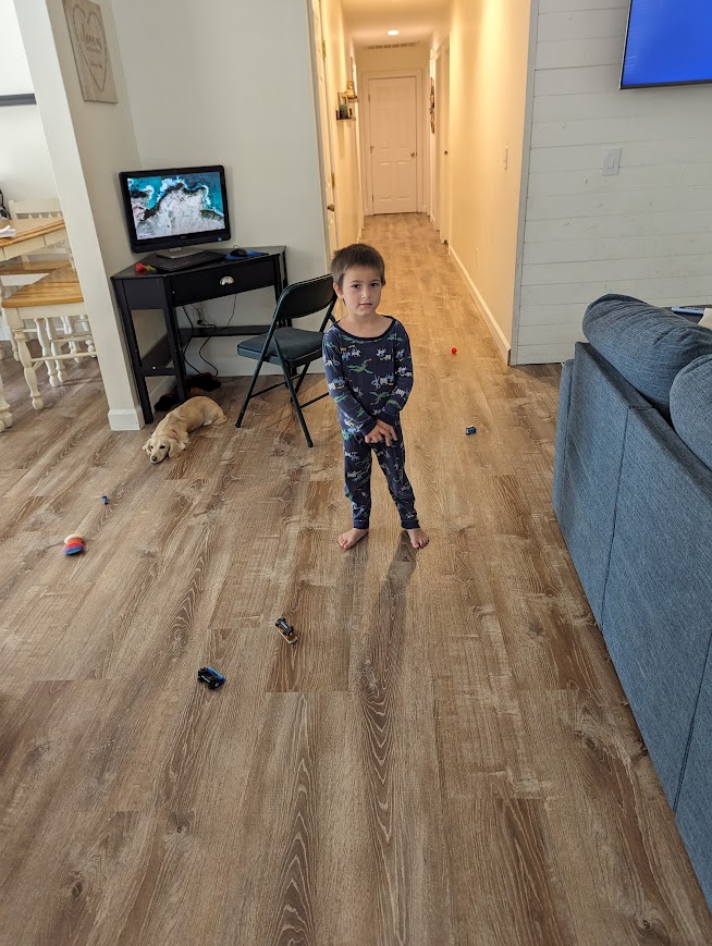 Boy standing with toys scattered on the floor