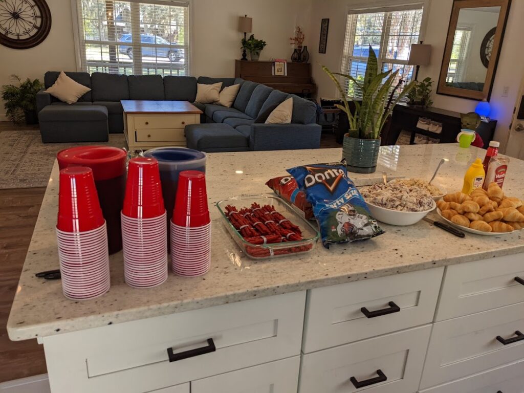 Kitchen island with party food and tidy living room in background