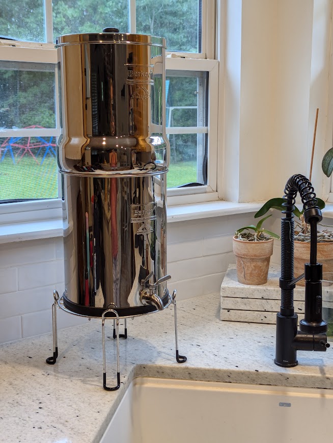 Silver Berkey water filter in kitchen beside sink