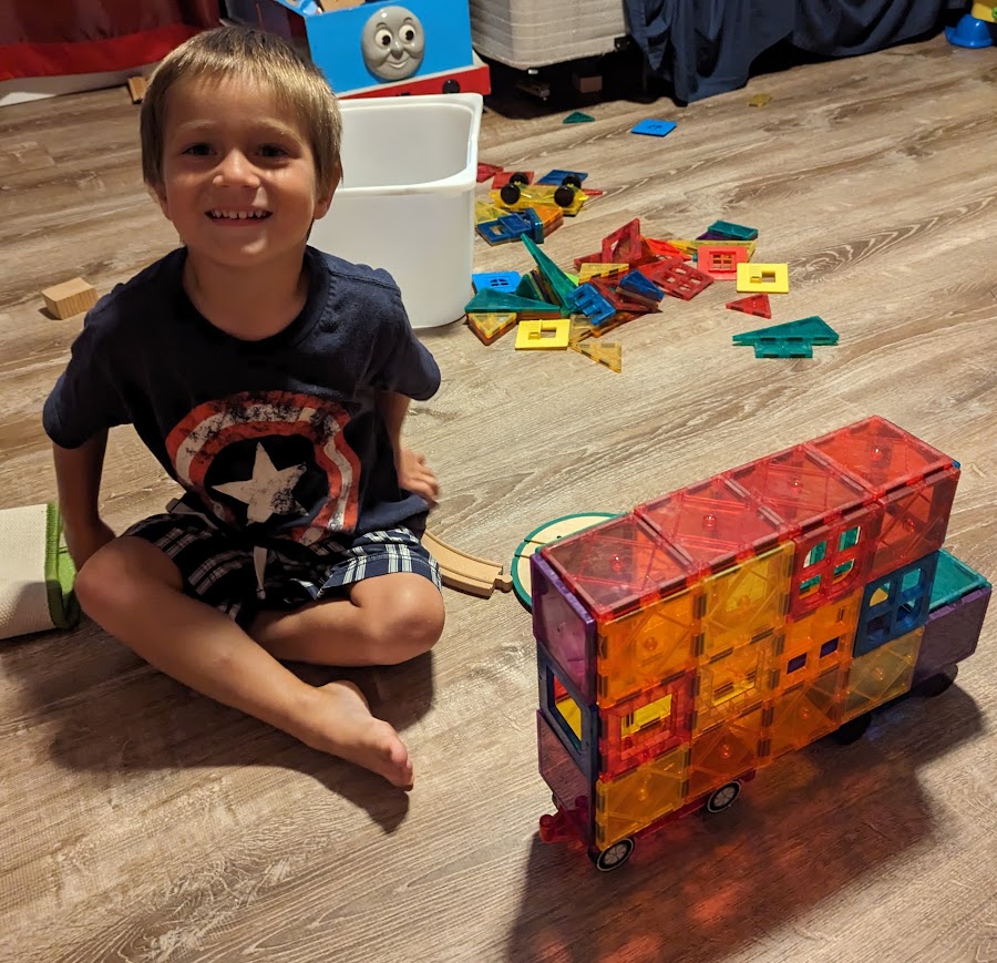 Truck made with magnatiles with child
