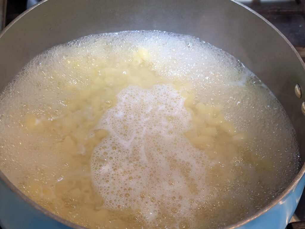 Elbow noodles cooking in a pot of boiling water