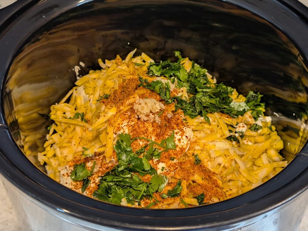 Crockpot full of ingredients for Hot Mexican Corn Dip