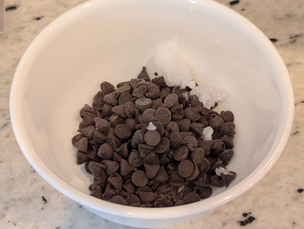 Bowl with healthy chocolate chips and coconut oil